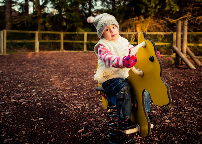Child riding her toy horse at the playground in Horley, Surrey