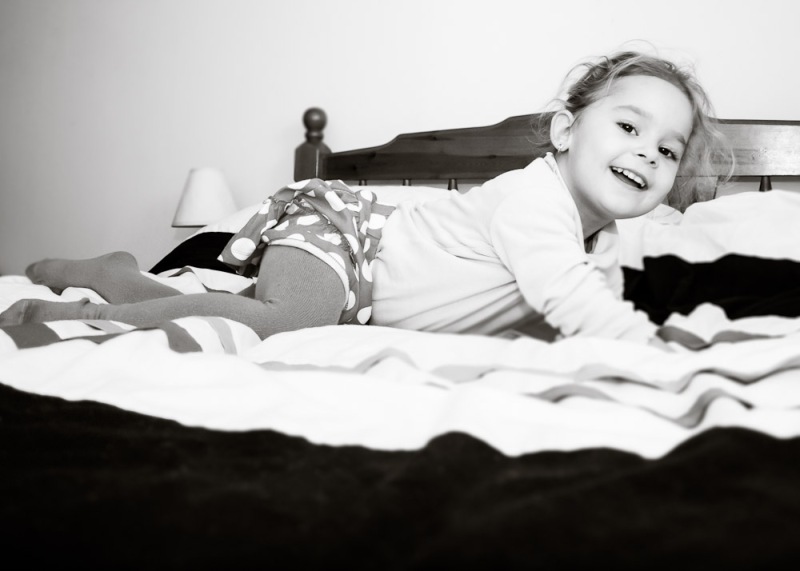 Child having fun in her parents' bed